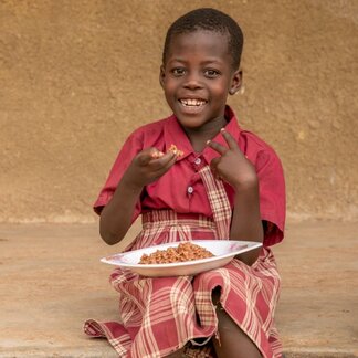 Stella Mporrago eating lunch at Straight Link Nursery, Primary and Secondary School in Juba. 