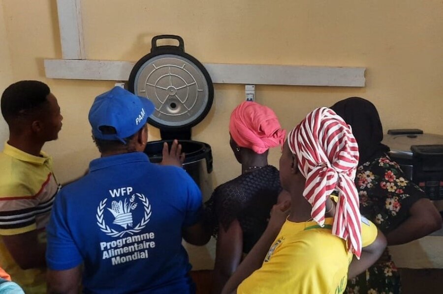 A WFP employee shows women in southern Guinea how to use solar-powered cookers to make WFP school meals. Photo: WFP/Youssouf Kaba&nbsp;