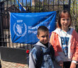 Two children wait at a WFP bread distribution site. Photo: WFP/Jonathan Dumont 