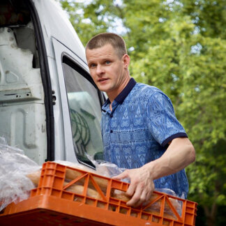a man is carrying a box full of bread