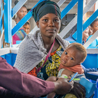 A mother and baby attend a health centre established as part of  scale-Up efforts in Eastern DRC.